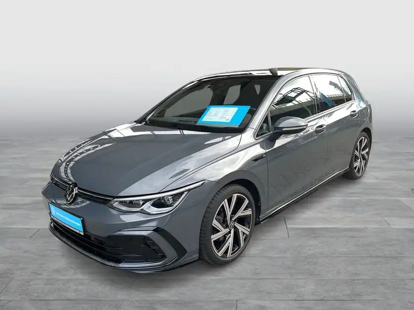 Das Bild zeigt einen grauen VW Golf aus seitlicher Perspektive. Es ist ein Händlerlogo sichtbar und es gibt markante Texteinblendungen.