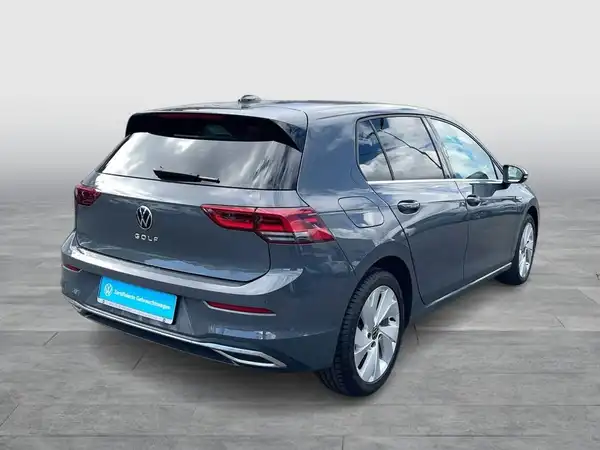 Das Bild zeigt einen grauen Volkswagen Golf aus der Rückansicht. Das Händelerlogo ist sichtbar und markante Texteinblendungen sind vorhanden.