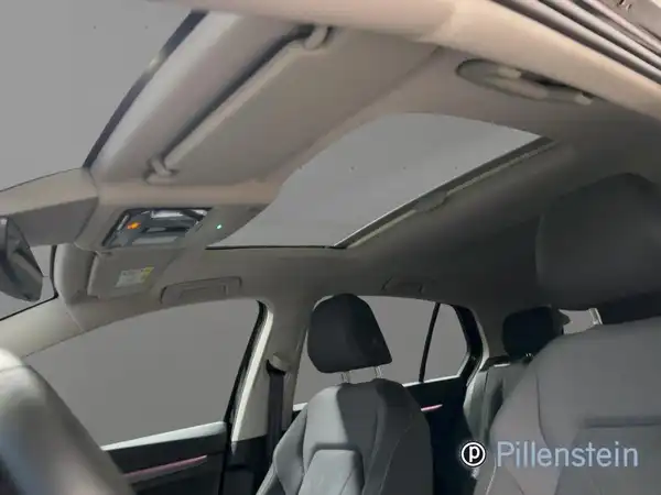 Innenaufnahme eines Fahrzeugs mit schwarzem Interieur und Schiebedach.