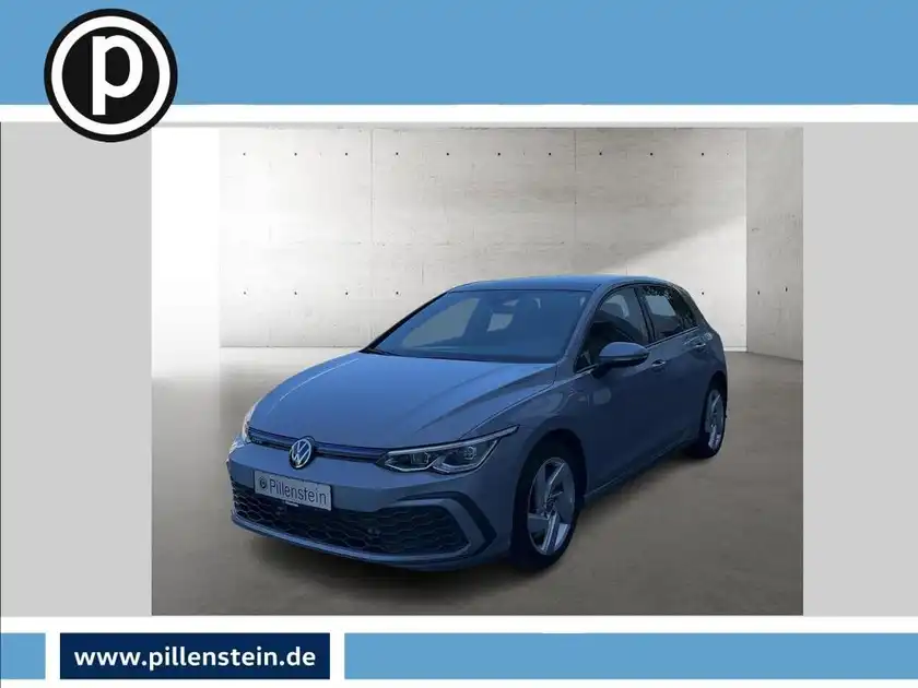 Das Bild zeigt einen blauen VW Golf GTI aus der Vorderansicht. Es ist ein Händlerlogo im Bild integriert.