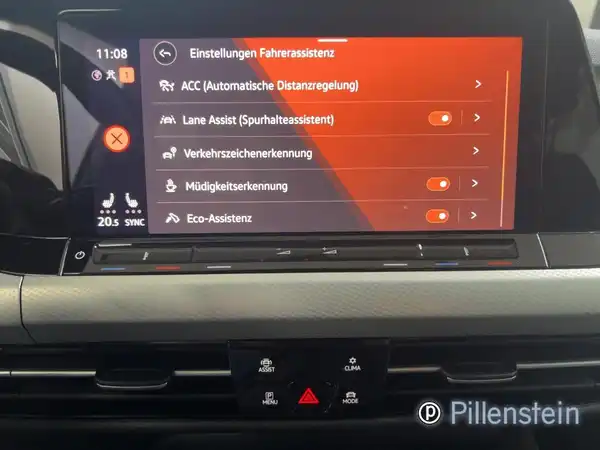 Das Bild zeigt das Innenleben eines VW Golf Variant mit einer Anzeige für das Fahrassistenzsystem. Das Interieur ist schwarz. Es ist ein Händlersymbol von Pillenstein eingeblendet.