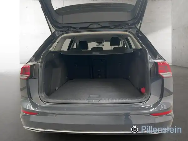 Das Bild zeigt die Rückansicht des VW Golf Variant in grau mit offenem Kofferraum.