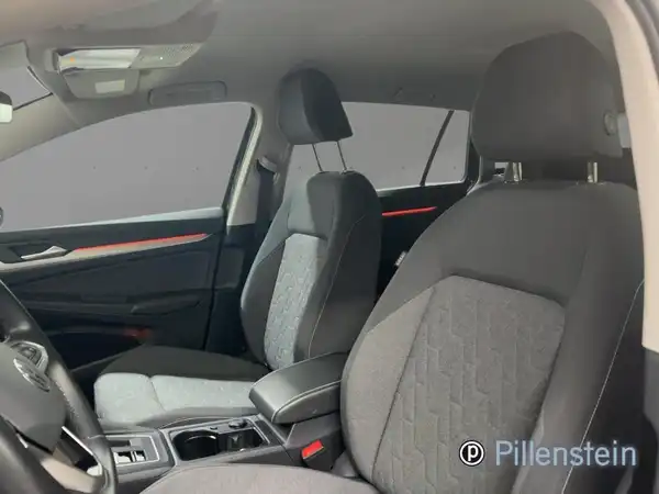 Eine Innenaufnahme des VW Golf Variant, es sind schwarze Sitze sichtbar und das Händlersymbol ist im Bild eingebettet.