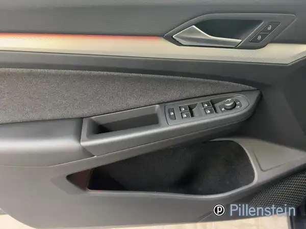 Das Bild zeigt die Innenseite der Fahrertür eines VW Golf Variant. Der Türbereich ist in schwarz gehalten und enthält Bedienelemente für Fensterheber und andere Funktionen.