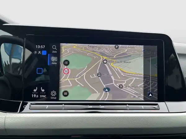 Das Bild zeigt den Innenraum eines Fahrzeugs mit einem Navigationsdisplay, das eine Karte anzeigt.