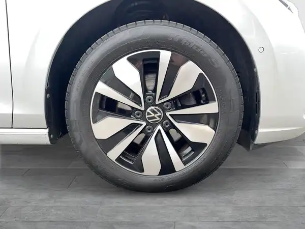 Das Bild zeigt die Seite eines weißen VW Golf, insbesondere eine Nahaufnahme eines Rades.