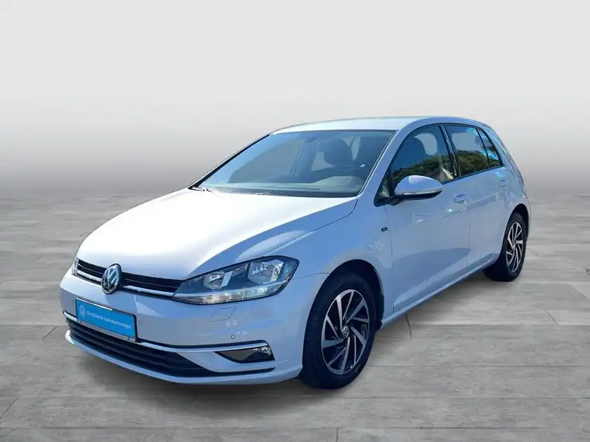 Das Bild zeigt einen weißen VW Golf aus der Frontalansicht.