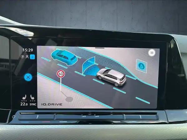 Das Bild zeigt den Innenraum eines Fahrzeugs mit einem Infotainment-System, auf dem eine Navigationsgrafik angezeigt wird.