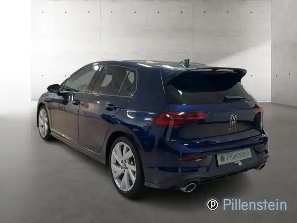 Das Bild zeigt einen blauen VW Golf GTI von hinten, aufgenommen in einem Innenraum.