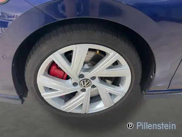 Das Bild zeigt das Rad eines blauen VW Golf GTI von der Seite, einschließlich der Felge und Bremse. Es enthält das Händlerlogo und ist ein Fahrzeugbild.