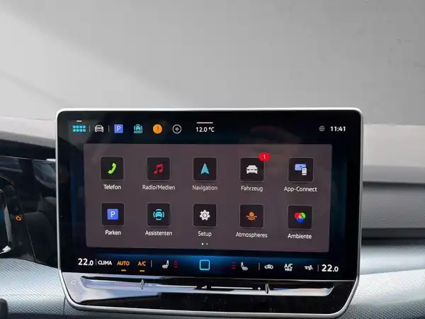 Das Bild zeigt das Innenleben eines VW GOLF, insbesondere den Bildschirm des Infotainment-Systems. Der Bildschirm hat verschiedene Symbole für Funktionen wie Navigation, Medien und Einstellungen. Das Interieur ist in Schwarz gehalten.