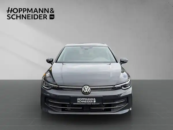 Das Bild zeigt einen schwarzen VW Golf von vorne. Es ist ein normaler Fahrzeugblick und enthält das Händlerlogo HOPPMANN & SCHNEIDER.
