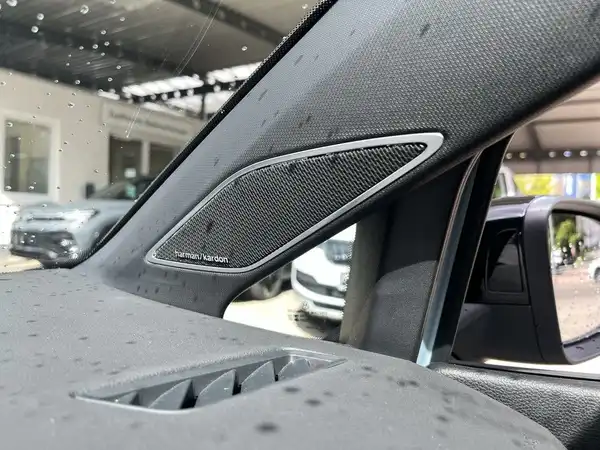 Das Bild zeigt das Interieur des Fahrzeugs, das von innen aufgenommen wurde. Es ist ein schwarzes Armaturenbrett mit einem Lautsprecher und möglicherweise einer markanten Texteinblendung.