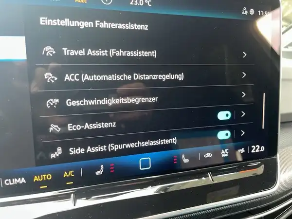 Das Bild zeigt eine Innenaufnahme des Fahrzeugs, spezifisch vom Navigations- oder Infotainmentsystem, mit verschiedenen Einstellungen zum Fahrerassistenzsystem in Schwarz.