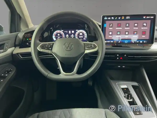 Das Bild zeigt das Innere eines VW Golf Variant mit einem dunklen Innenraum und modernen Anzeigeelementen.