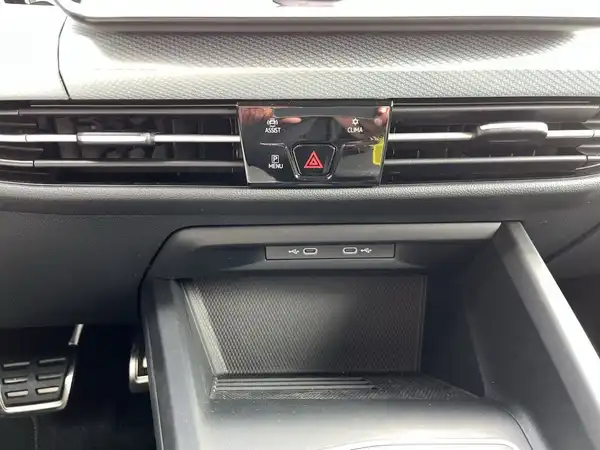 Eine Innenaufnahme des Fahrzeugs (VW Golf) mit schwarzen Interieurelementen, die Bedienelemente und Lüftungsschlitze zeigt.