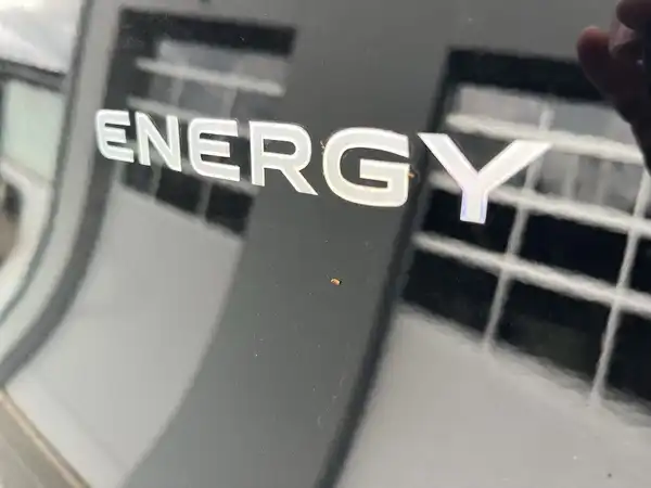 Das Bild zeigt das Heck eines Fahrzeugs mit dem Schriftzug 'ENERGY' auf der Rückseite. Es handelt sich um einen schwarzen VW GOLF, aufgenommen von hinten.