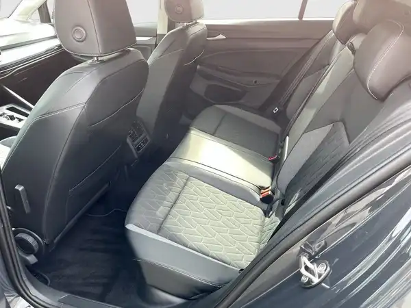 Das Bild zeigt den Innenraum eines VW Golf, aufgenommen von der Rückbank. Die Sitze sind schwarz mit einem gemusterten Stoff.