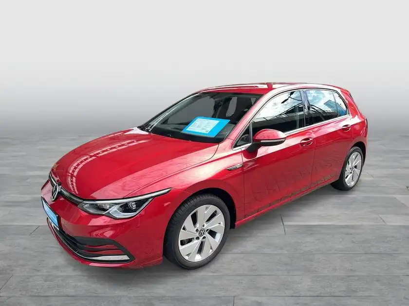 Das Bild zeigt einen roten VW Golf, aufgenommen von der Seite. Es gibt eine markante Texteinblendung im oberen Bereich des Bildes.