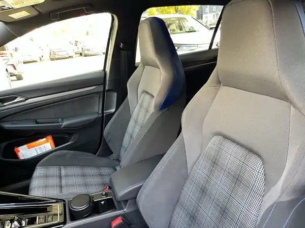 Das Bild zeigt eine Innenaufnahme des Fahrzeugs, mit grauen Sitzen, die kariert sind.