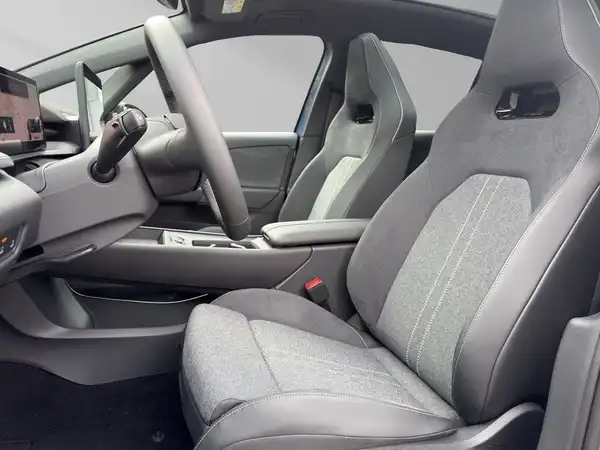 Das Bild zeigt den Innenraum eines VW ID.3, aufgenommen aus einem Blickwinkel, der die Sitze und das Armaturenbrett zeigt.