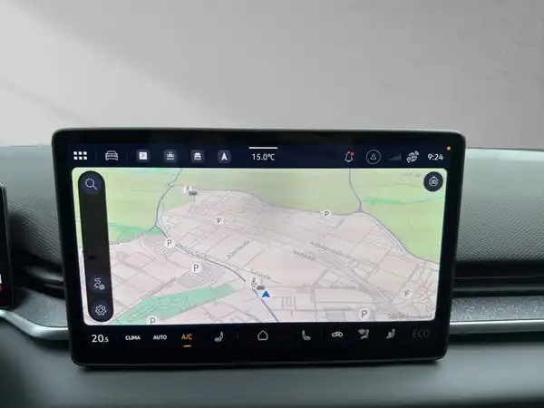 Das Bild zeigt das Innere eines Fahrzeugs mit einem Navigationsgerät, das eine Karte anzeigt. Der Blickwinkel ist von innen.