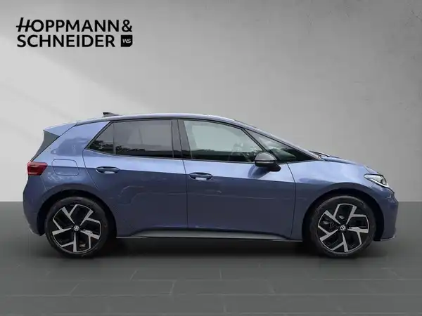 Das Bild zeigt einen VW ID.3 in blauer Farbe, aufgenommen von der Seite, mit dem Händlerlogo 'HOPPMANN & SCHNEIDER' im Hintergrund.