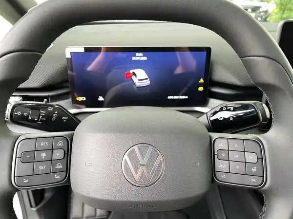 Innenaufnahme des VW ID.3 mit schwarzem Interieur, zeigt das Armaturenbrett und einen Bildschirm mit digitalen Anzeigen.