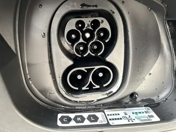 Das Bild zeigt die Ladebuchse des Fahrzeugs, es handelt sich um eine Innenaufnahme der Ladeeinheit.
