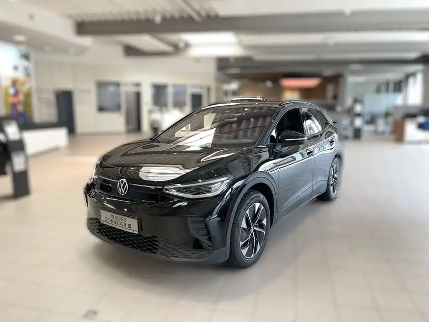 Das Bild zeigt einen schwarzen VW ID.4 aus der Frontansicht in einem Verkaufsraum.