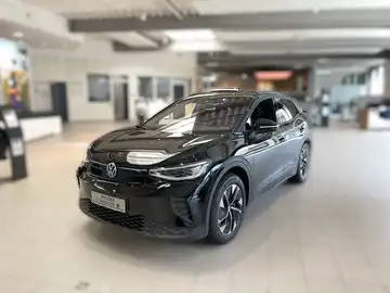 Das Bild zeigt einen schwarzen VW ID.4 aus der Frontansicht in einem Verkaufsraum.