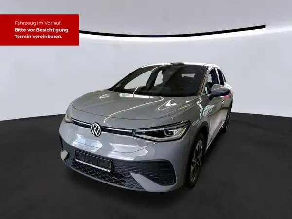 Das Bild zeigt einen silbernen VW ID.5 PRO von vorne. Im Hintergrund ist ein rotes Textfeld sichtbar, das zur Terminvereinbarung einlädt.