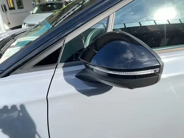 Das Bild zeigt die Seite des Fahrzeugs, einen silbernen VW ID.7, mit dem Fokus auf den Außenspiegel.
