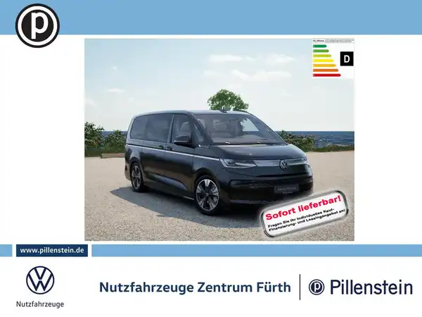Ein seitliches Bild eines schwarzen VW Multivan, das für den Verkauf präsentiert wird. Im Hintergrund eine Landschaftsaufnahme. Das Händlerlogo ist sichtbar und enthält eine markante Texteinblendung: 'Sofort lieferbar'.