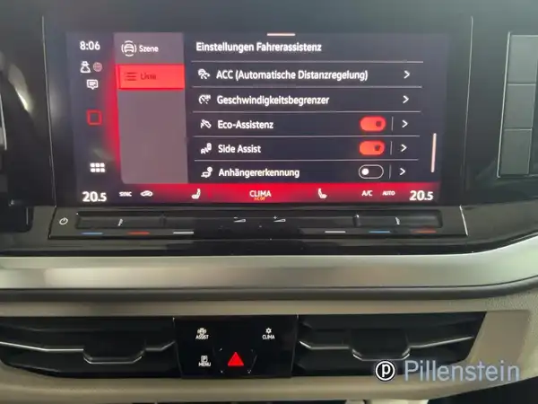 Das Bild zeigt das innere eines VW Multivan mit einem Bildschirm, der Einstellungen für den Fahrassistenten anzeigt. Das Interieur ist schwarz und auf dem Bildschirm sind verschiedene Optionen zur Fahrassistenz sichtbar.