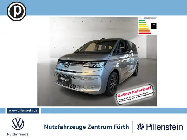 Das Bild zeigt einen VW Multivan in silberner Farbe von der Seite. Es enthält das Händlerlogo sowie markante Texteinblendungen und Informationen zur sofortigen Verfügbarkeit.