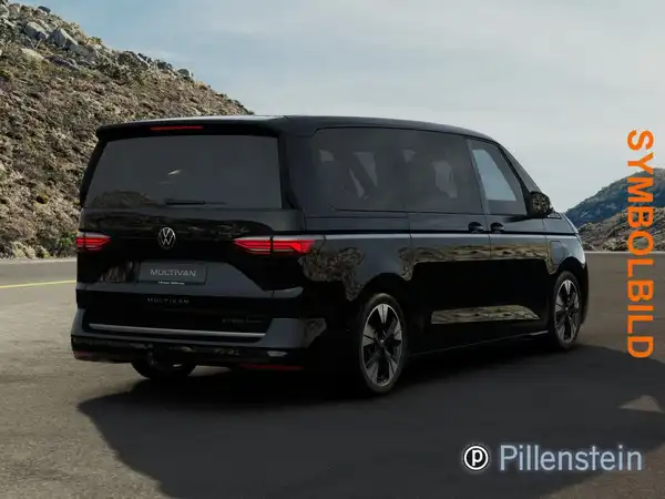 Das Bild zeigt einen schwarzen VW Multivan von hinten auf einer Straße mit Bergen im Hintergrund. Das Händlerinformationen ist in der Ecke platziert.