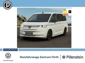 Das Bild zeigt einen weißen Volkswagen Multivan von vorne, mit sichtbarem Händlerlogo und weiteren markanten Texteinblendungen.