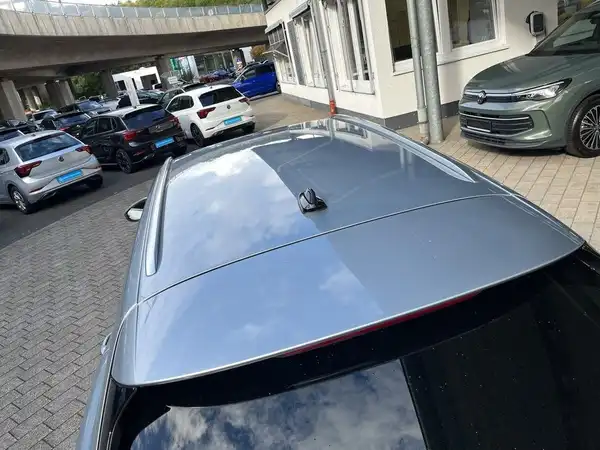 Das Bild zeigt die Rückansicht eines silbernen VW Passat Variant, aufgenommen von einer erhöhten Perspektive. Im Hintergrund sind weitere Fahrzeuge sichtbar.