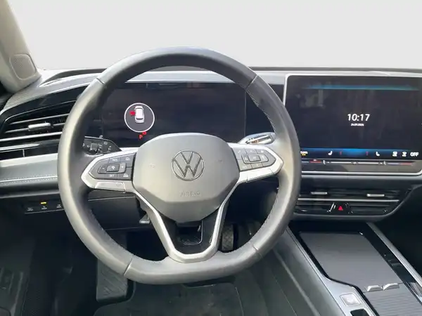 Innenaufnahme des VW Passat Variant mit einem schwarzen Interieur und einem sichtbaren Bildschirm, ausgestattet mit markanten Texteinblendungen.