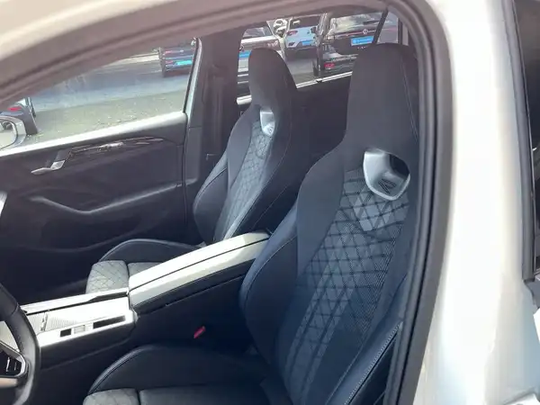 Das Bild zeigt den Innenraum eines Fahrzeugs mit schwarzen Sitzen.