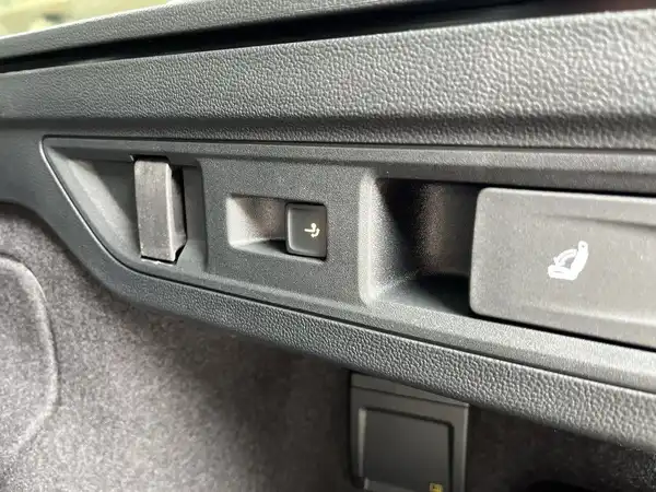 Eine Innenaufnahme des Kofferraums eines schwarzen VW Passat Variant, die mit grauem Material ausgekleidet ist.
