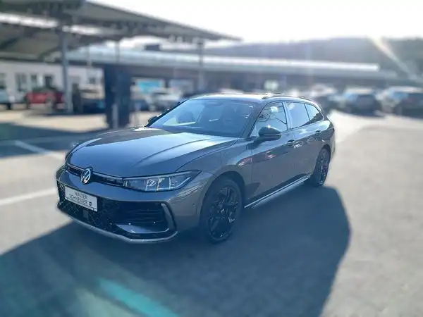 Das Bild zeigt einen grauen VW Passat von der Seite, mit einem Händlerlogo und markantem Text.