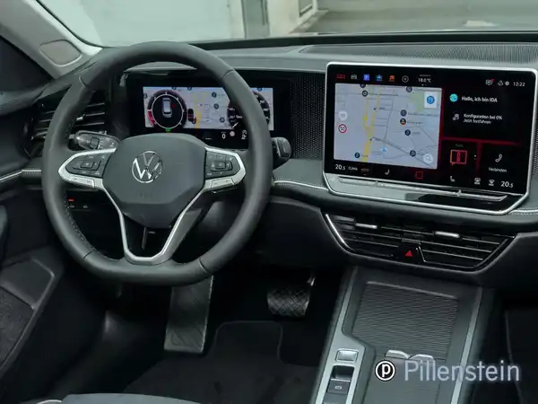 Das Bild zeigt das Innere eines VW Passat Variant mit schwarzem Interieur, inklusive Armaturenbrett und Touchscreen-Displays.