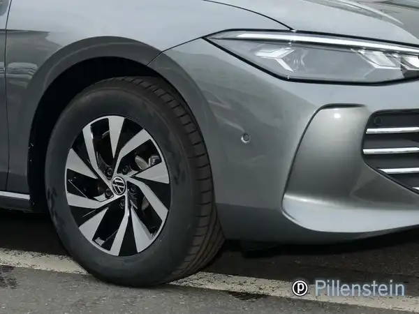 Das Bild zeigt einen grauen VW Passat Variant von der Seite mit einem gut sichtbaren Rad und einer Markierung des Händlers.