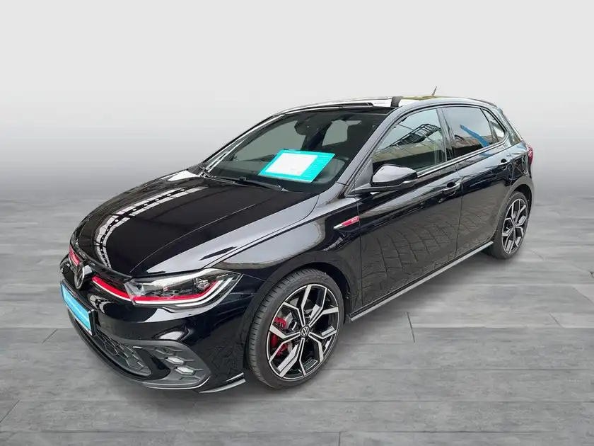 Das Bild zeigt einen schwarzen VW Polo GTI von der Seite. Das Händlerequipment ist sichtbar, sowie ein markanter Texteinblendung.