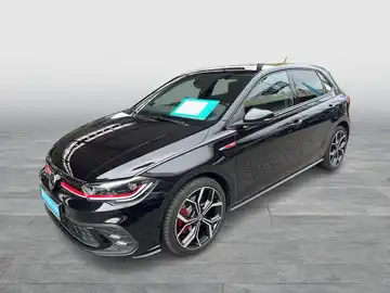 Das Bild zeigt einen schwarzen VW Polo GTI von der Seite. Das Händlerequipment ist sichtbar, sowie ein markanter Texteinblendung.