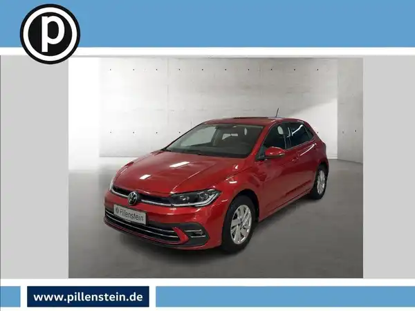 Das Bild zeigt einen roten VW Polo aus der Frontansicht. Das Fahrzeug ist in einem Ausstellungshintergrund platziert, wobei ein Händlerlogo sichtbar ist.