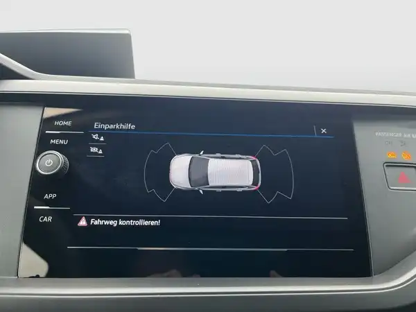 Das Bild zeigt das Innenraumdisplay eines Fahrzeugs mit Angaben zur Einparkhilfe und Warnhinweisen.