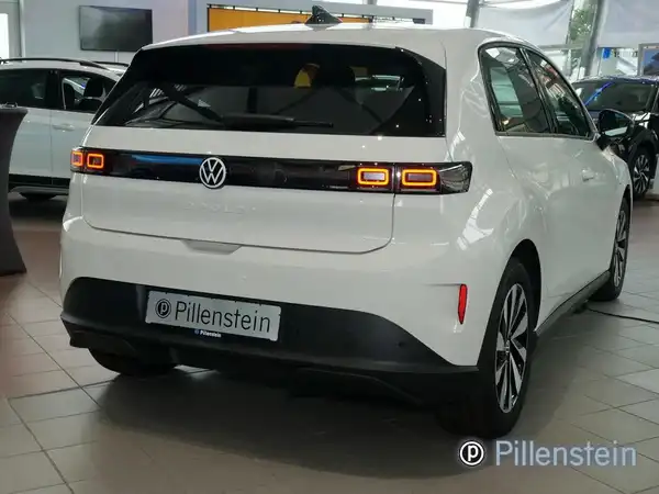 Das Bild zeigt einen weißen VW Polo von hinten in einem Autohaus. Es ist das Händlerlogo von Pillenstein zu erkennen.